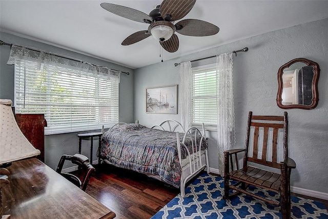 bedroom with dark hardwood / wood-style floors and ceiling fan