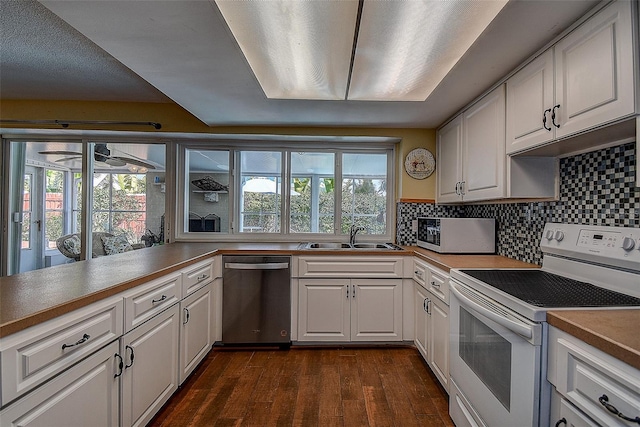 kitchen with white electric range, dishwasher, a sink, and white cabinetry