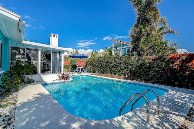 view of pool with a fenced in pool, fence private yard, a sunroom, and a patio