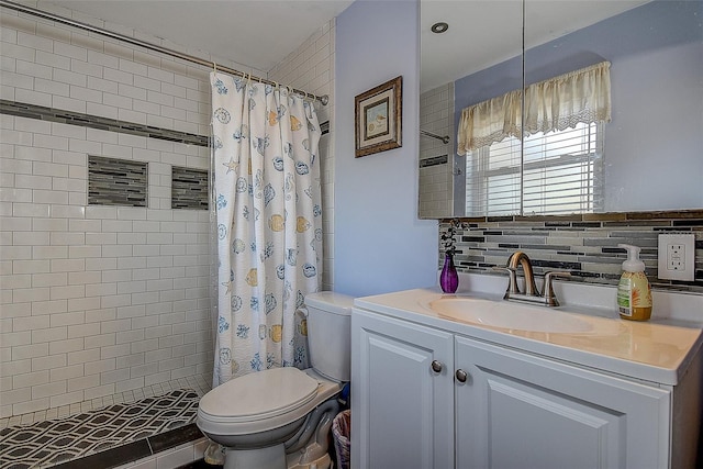 bathroom featuring tasteful backsplash, a tile shower, vanity, and toilet