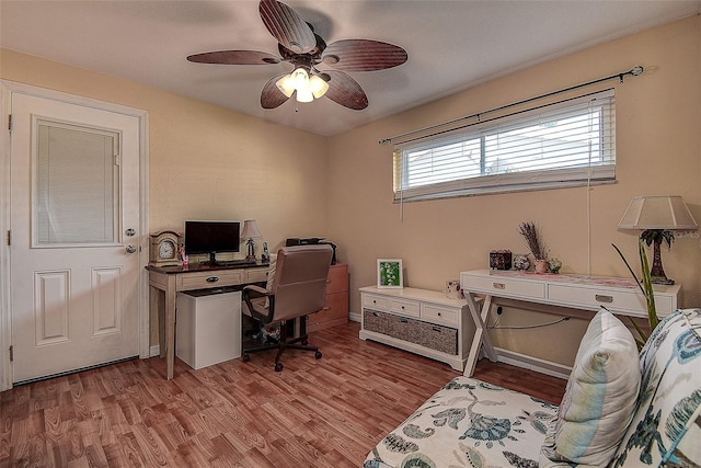 home office featuring light wood-type flooring, ceiling fan, and baseboards