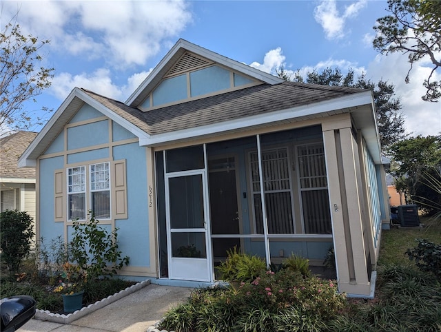 view of front of property with central AC and a sunroom