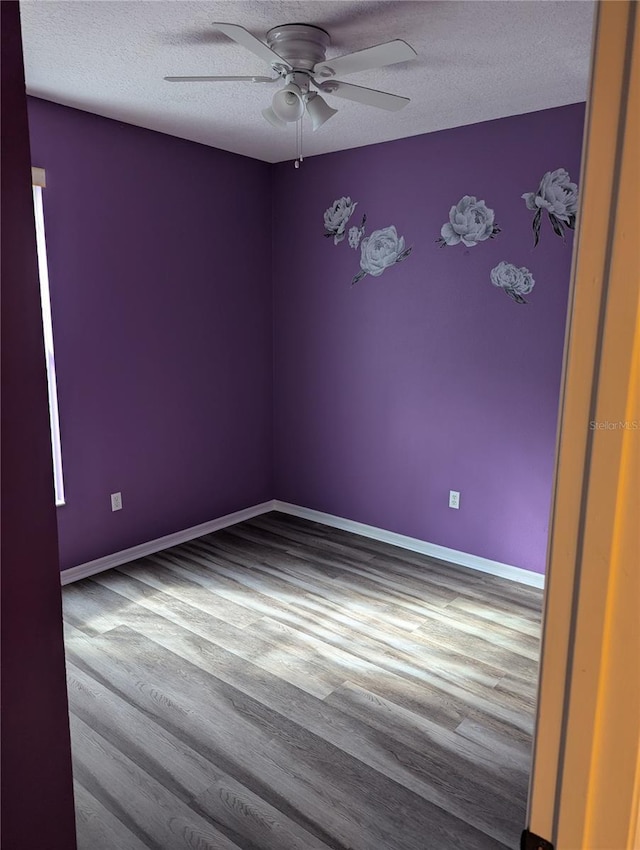 empty room with ceiling fan, a textured ceiling, and light hardwood / wood-style flooring