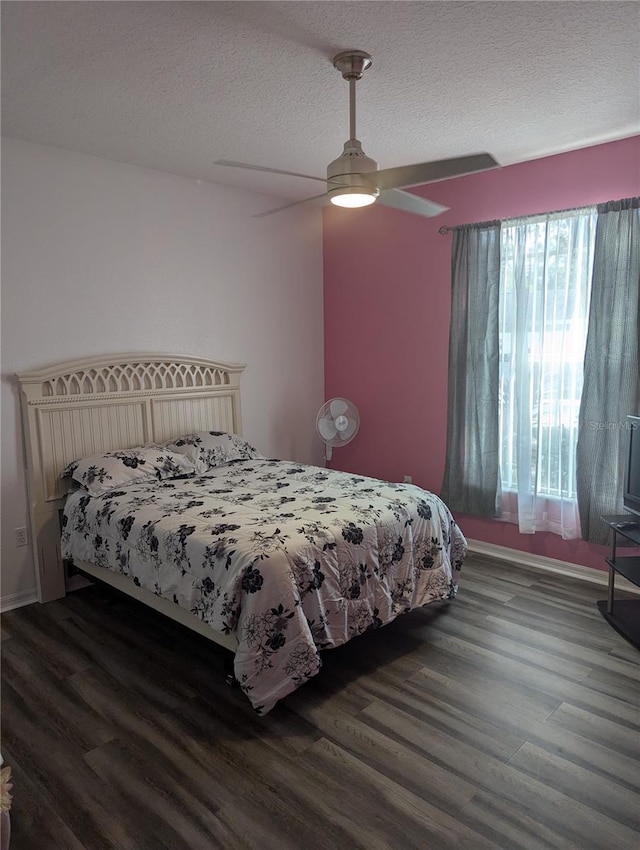 bedroom with a textured ceiling, dark hardwood / wood-style flooring, and ceiling fan