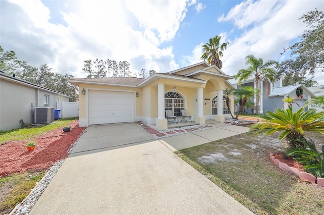 view of front of home with a porch, a garage, and central AC unit