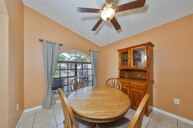 dining room featuring ceiling fan, lofted ceiling, a textured ceiling, and light tile patterned floors