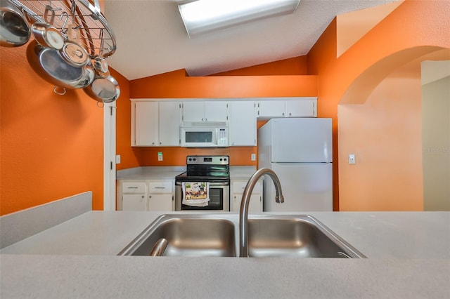 kitchen featuring white cabinets, lofted ceiling, white appliances, and sink