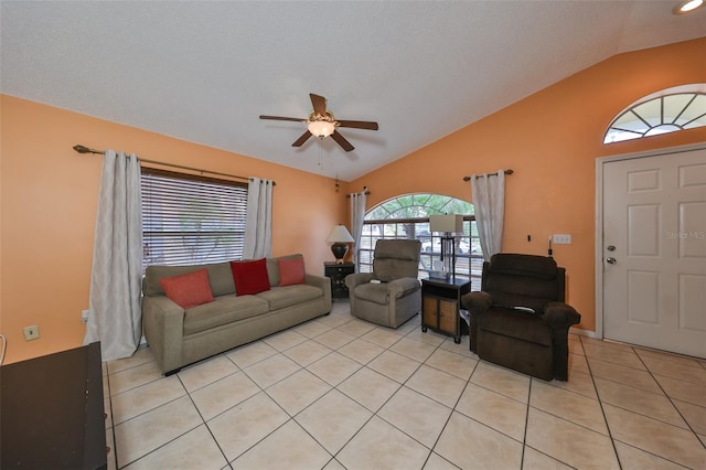 tiled living room with ceiling fan and vaulted ceiling