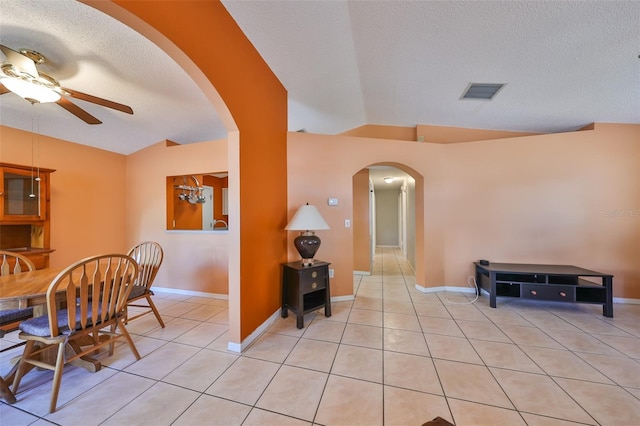 interior space featuring a textured ceiling, ceiling fan, and lofted ceiling