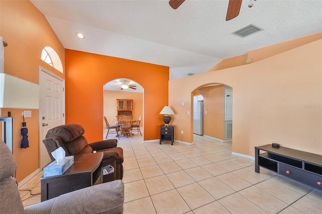 tiled living room featuring a textured ceiling, high vaulted ceiling, and ceiling fan