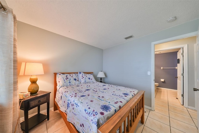 bedroom with light tile patterned floors and a textured ceiling