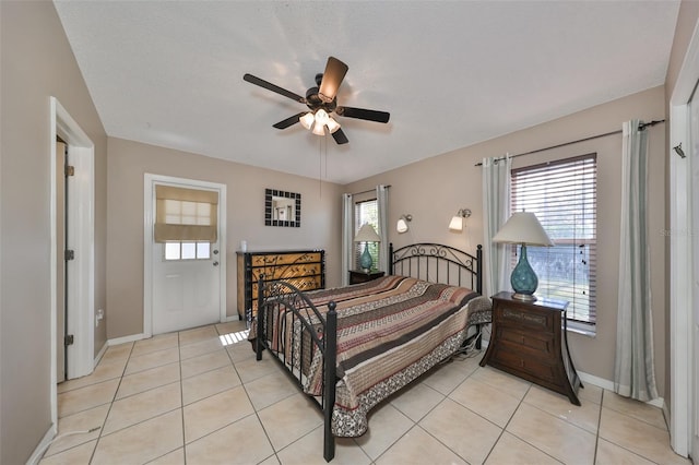 bedroom with ceiling fan, light tile patterned flooring, and multiple windows