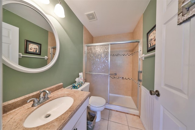 bathroom featuring tile patterned floors, vanity, toilet, and walk in shower