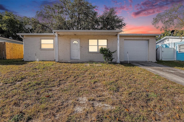 ranch-style home featuring a lawn and a garage