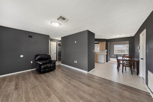 sitting room featuring a textured ceiling and light wood-type flooring