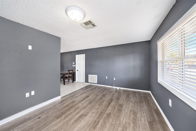 spare room with hardwood / wood-style floors and a textured ceiling