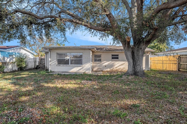 rear view of property with a lawn