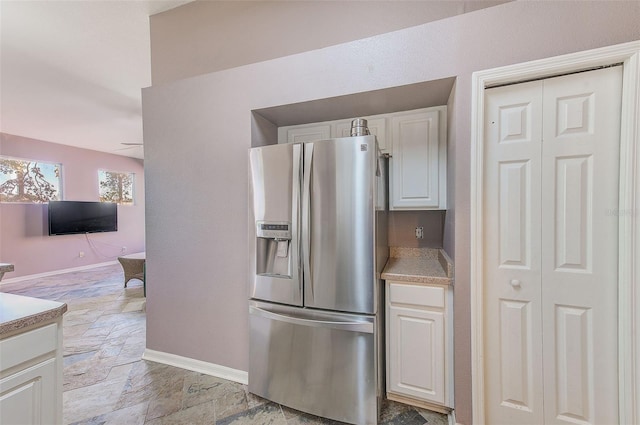 kitchen with white cabinets, stainless steel fridge with ice dispenser, and ceiling fan