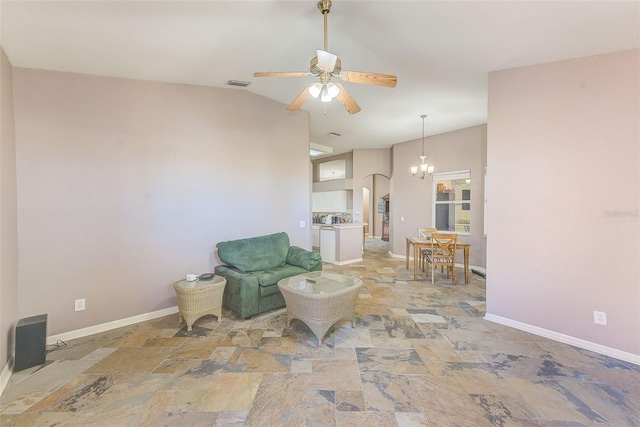 living area with ceiling fan with notable chandelier