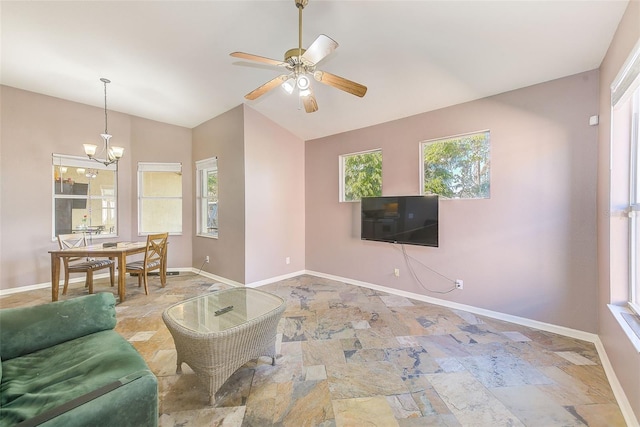 living room with plenty of natural light, ceiling fan with notable chandelier, and vaulted ceiling