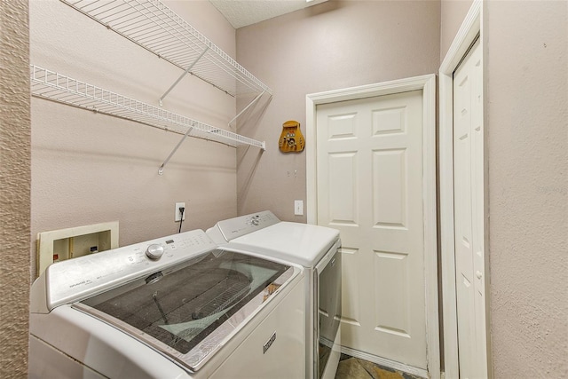 washroom with a textured ceiling and washing machine and clothes dryer