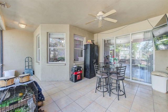 dining room featuring ceiling fan, light tile patterned floors, and a textured ceiling