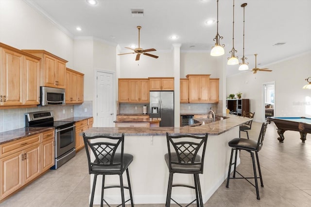 kitchen with stainless steel appliances, a center island with sink, and pool table