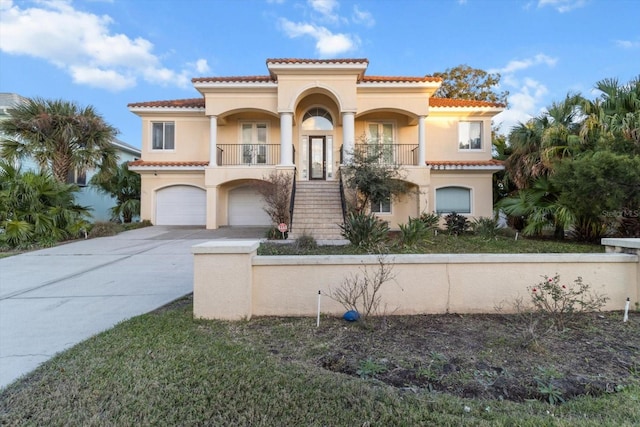 mediterranean / spanish house with covered porch and a garage