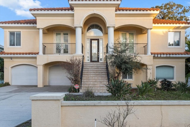 mediterranean / spanish house featuring a garage and a balcony