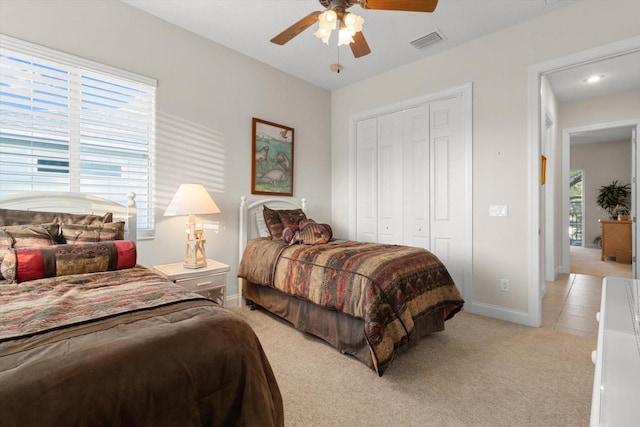 carpeted bedroom with ceiling fan and a closet