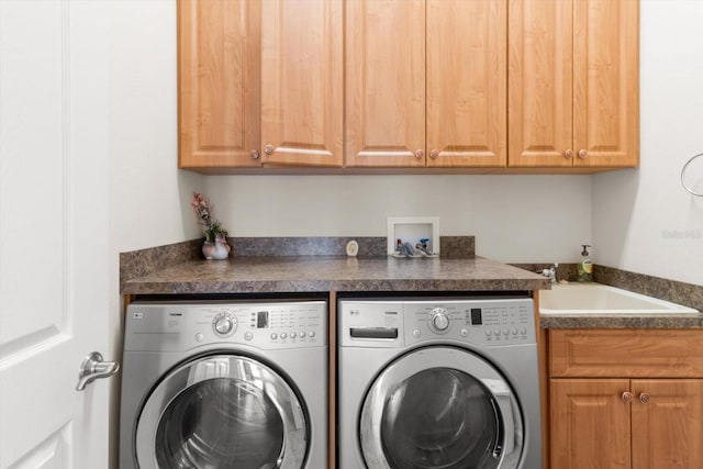 laundry area featuring washer and clothes dryer, cabinets, and sink