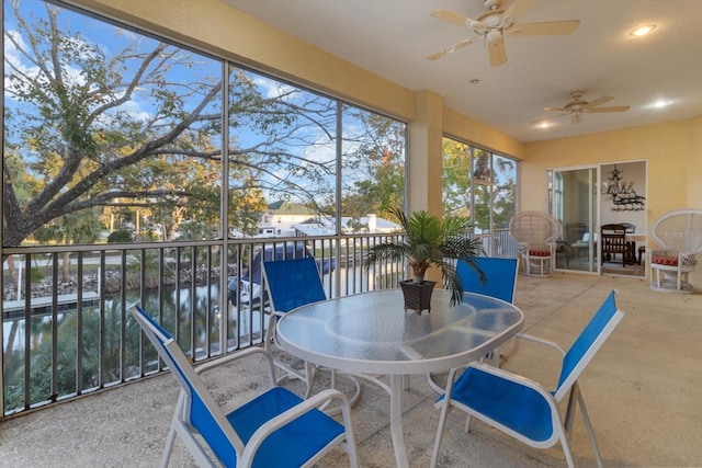 sunroom with a water view and ceiling fan