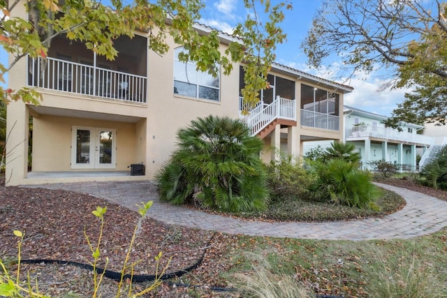 back of property featuring french doors, a patio area, and a sunroom