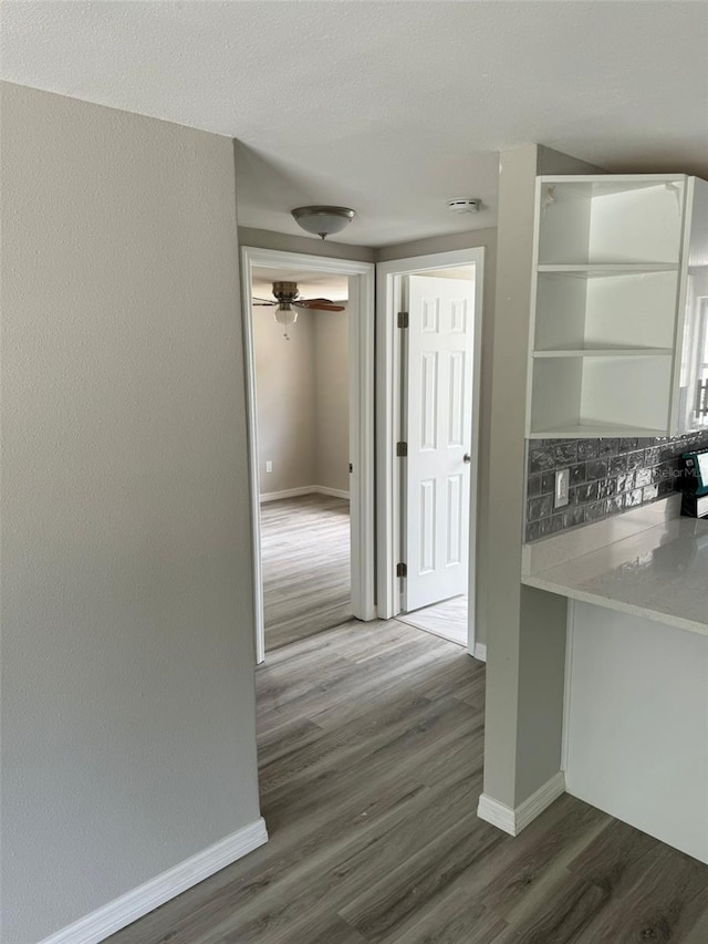 interior space featuring hardwood / wood-style floors, backsplash, white cabinetry, and ceiling fan