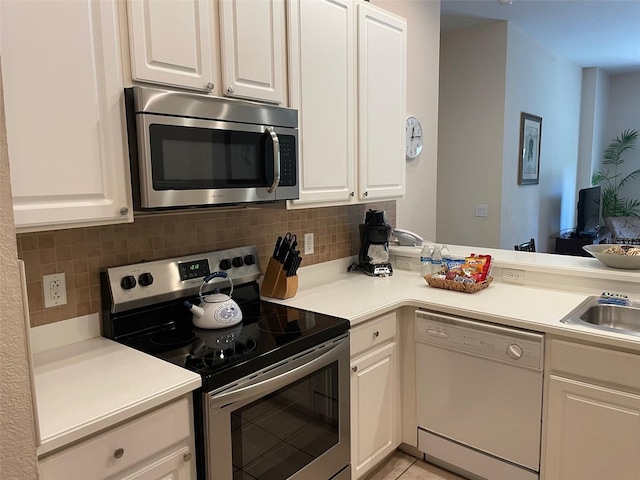 kitchen with decorative backsplash, white cabinetry, and stainless steel appliances