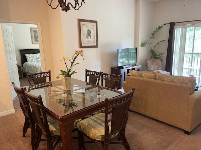 carpeted dining area featuring an inviting chandelier