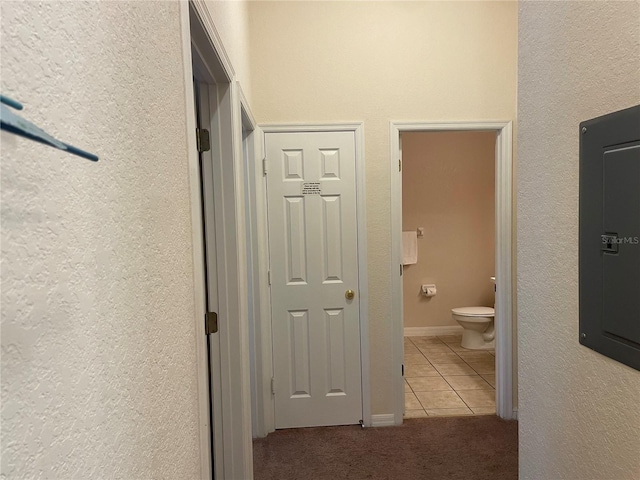 corridor with light tile patterned floors and electric panel