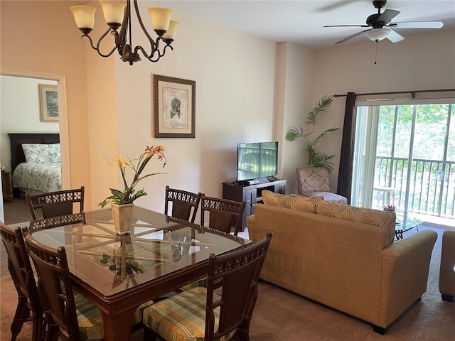 dining space featuring carpet flooring and ceiling fan with notable chandelier