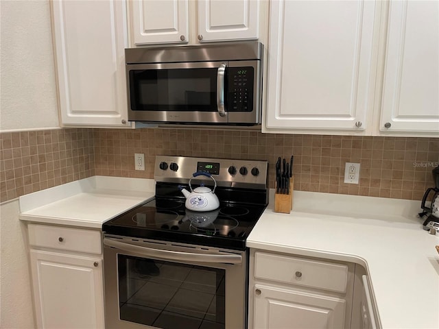 kitchen with white cabinets, decorative backsplash, and stainless steel appliances