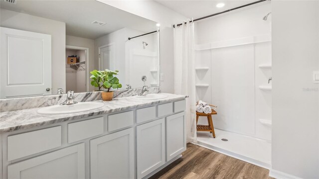 bathroom with vanity, wood-type flooring, and walk in shower