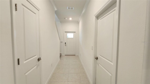 corridor with ornamental molding and light tile patterned floors