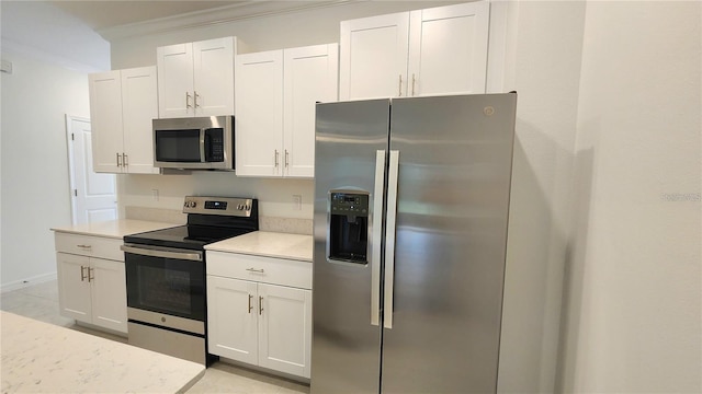 kitchen featuring stainless steel appliances, light tile patterned floors, crown molding, and white cabinetry