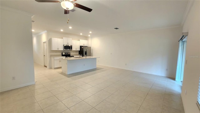 kitchen with appliances with stainless steel finishes, white cabinets, a center island with sink, and light tile patterned floors