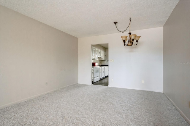 unfurnished room featuring dark colored carpet, a textured ceiling, and a chandelier