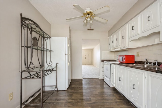 kitchen with dark hardwood / wood-style flooring, white appliances, a textured ceiling, ceiling fan, and white cabinetry