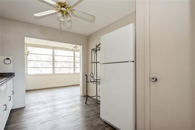 kitchen featuring white refrigerator, ceiling fan, decorative backsplash, dark hardwood / wood-style flooring, and white cabinetry