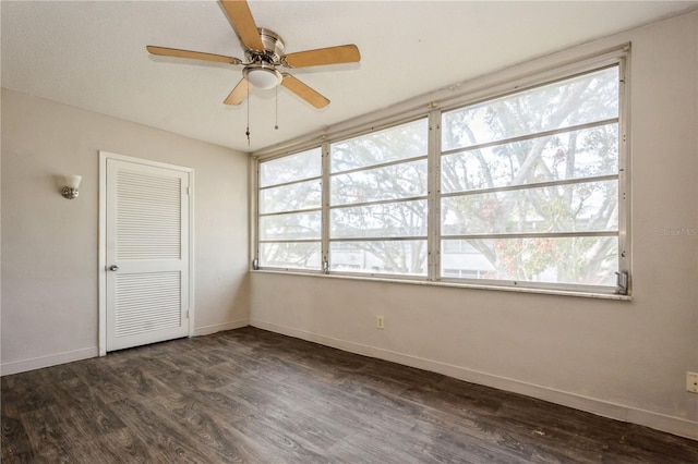 unfurnished bedroom with ceiling fan, a closet, and dark wood-type flooring