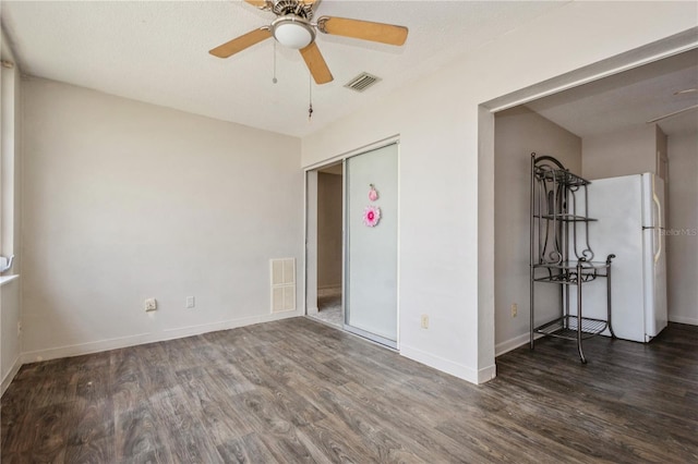 empty room featuring a textured ceiling, dark hardwood / wood-style floors, and ceiling fan