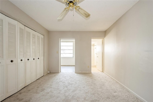 unfurnished bedroom with ceiling fan, a closet, and light colored carpet