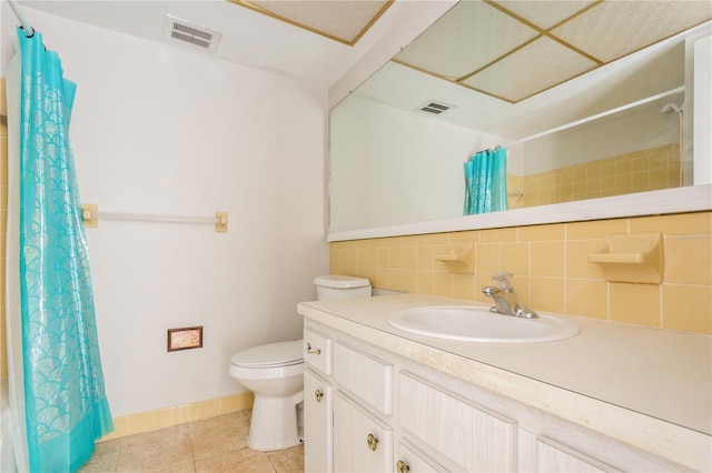 bathroom featuring vanity, tile patterned floors, toilet, walk in shower, and tasteful backsplash